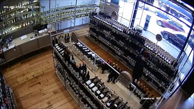 Мъж работник в магазин спасява бутилка с вино преди да падне и да се счупи
