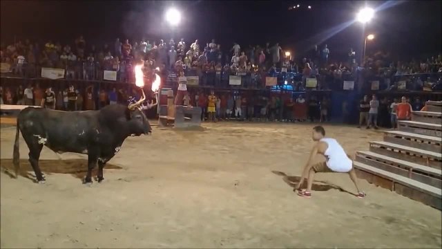 Страховито предизвикателство 2015! Мъж предизвика бик с горящи рога